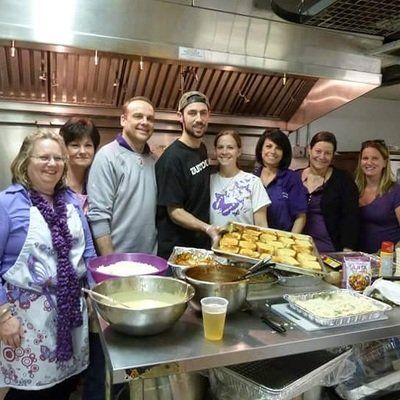 a group of people are posing for a picture in a kitchen