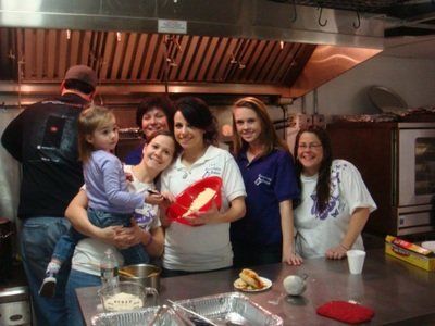 a group of people are posing for a picture in a kitchen .