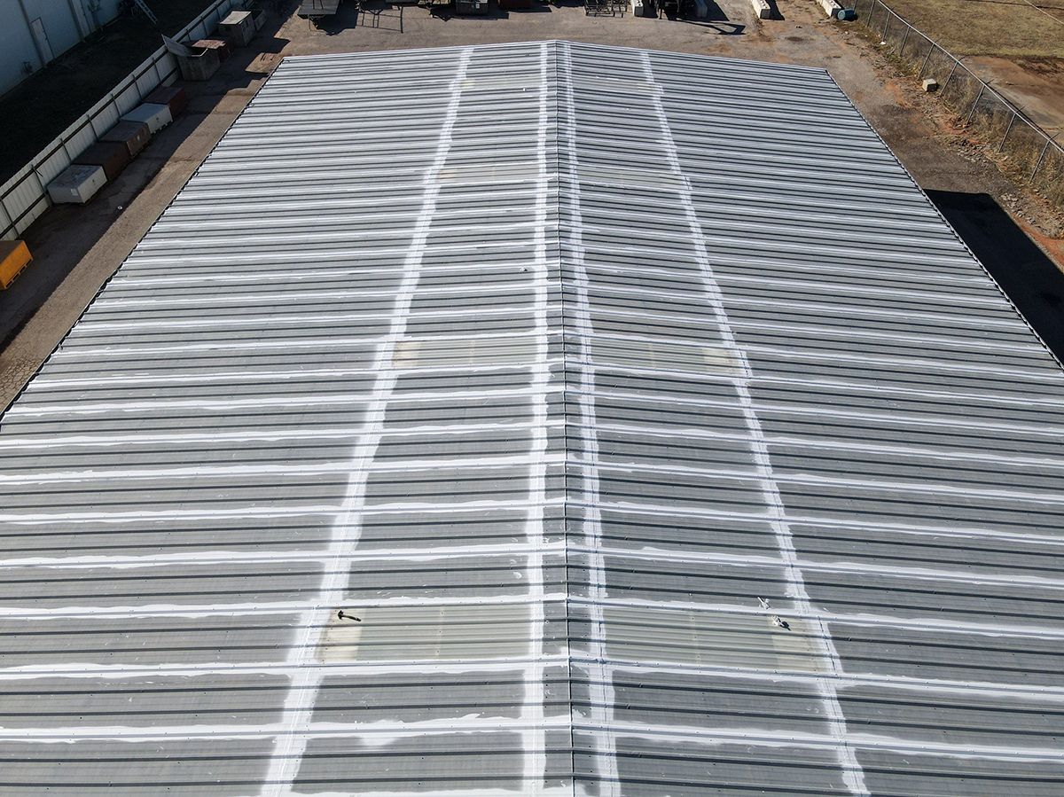 Aerial view of a corrugated metal roof painted with white lines in a grid pattern, outdoors.