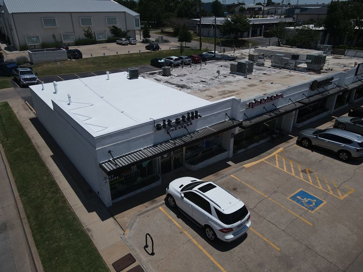 White SUV parked in front of a white commercial building with a handicap parking spot.
