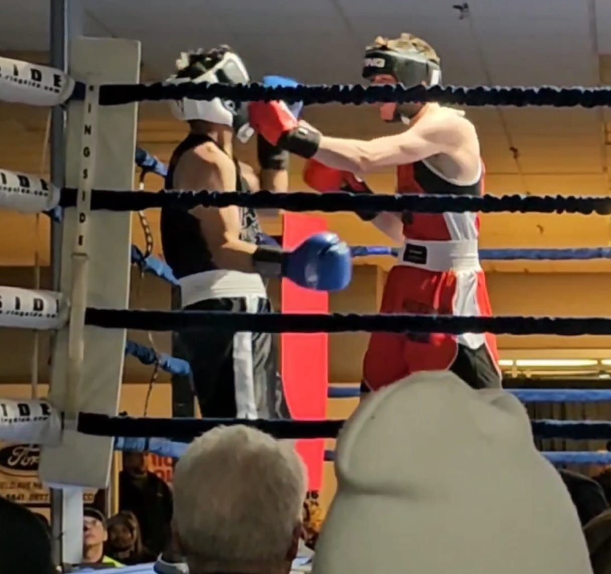 Two boxers are fighting in a ring with the letters ioi on the ropes