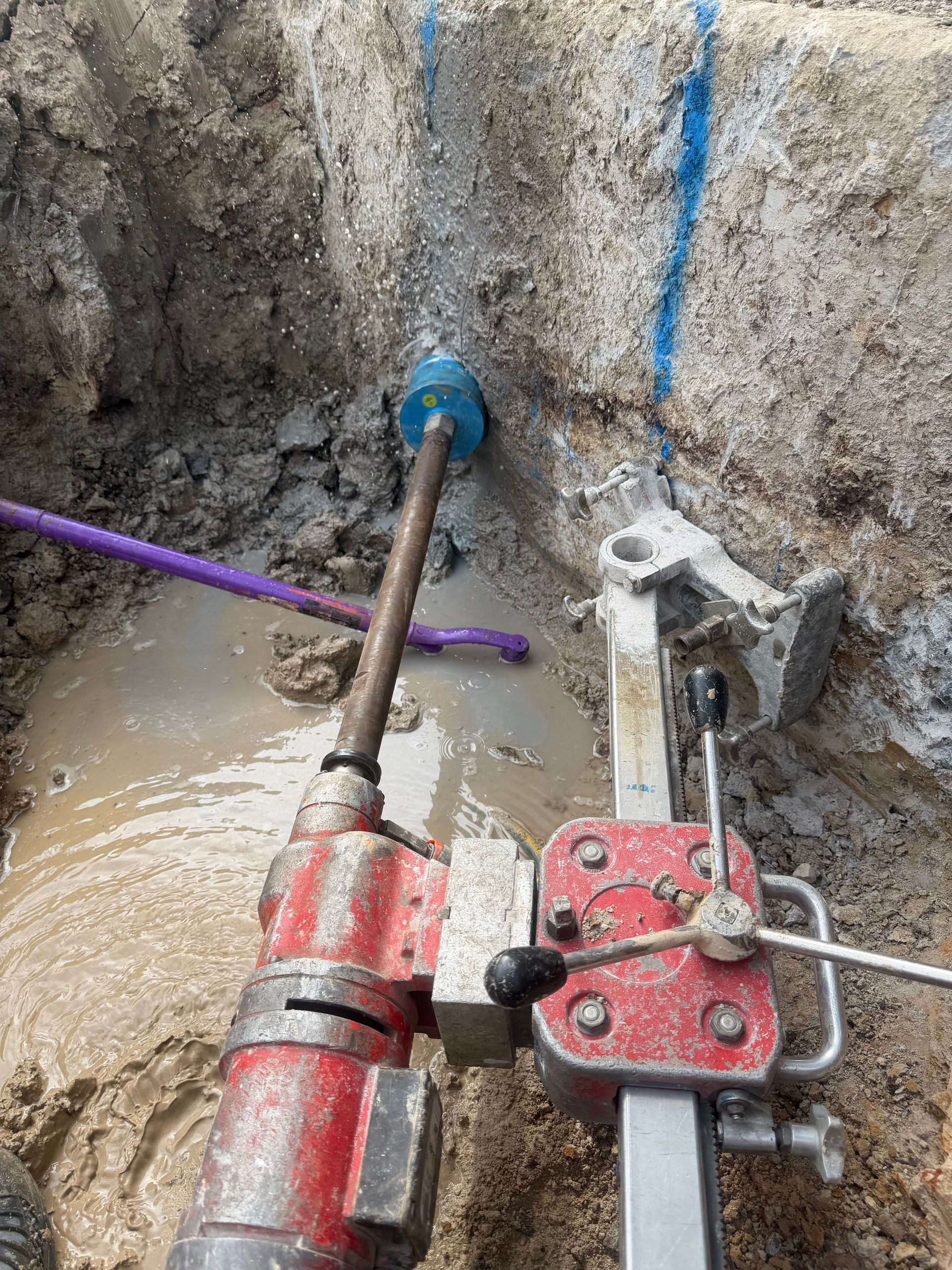 Person Drilling a Concrete Core Sample With a Red Drill — Coastcut Concrete Cutting Pty Ltd in Corlette, NSW