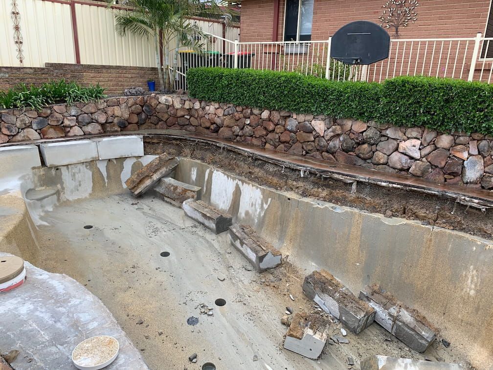 Empty Swimming Pool Under Renovation, With Scattered Debris  — Coastcut Concrete Cutting Pty Ltd in Corlette, NSW