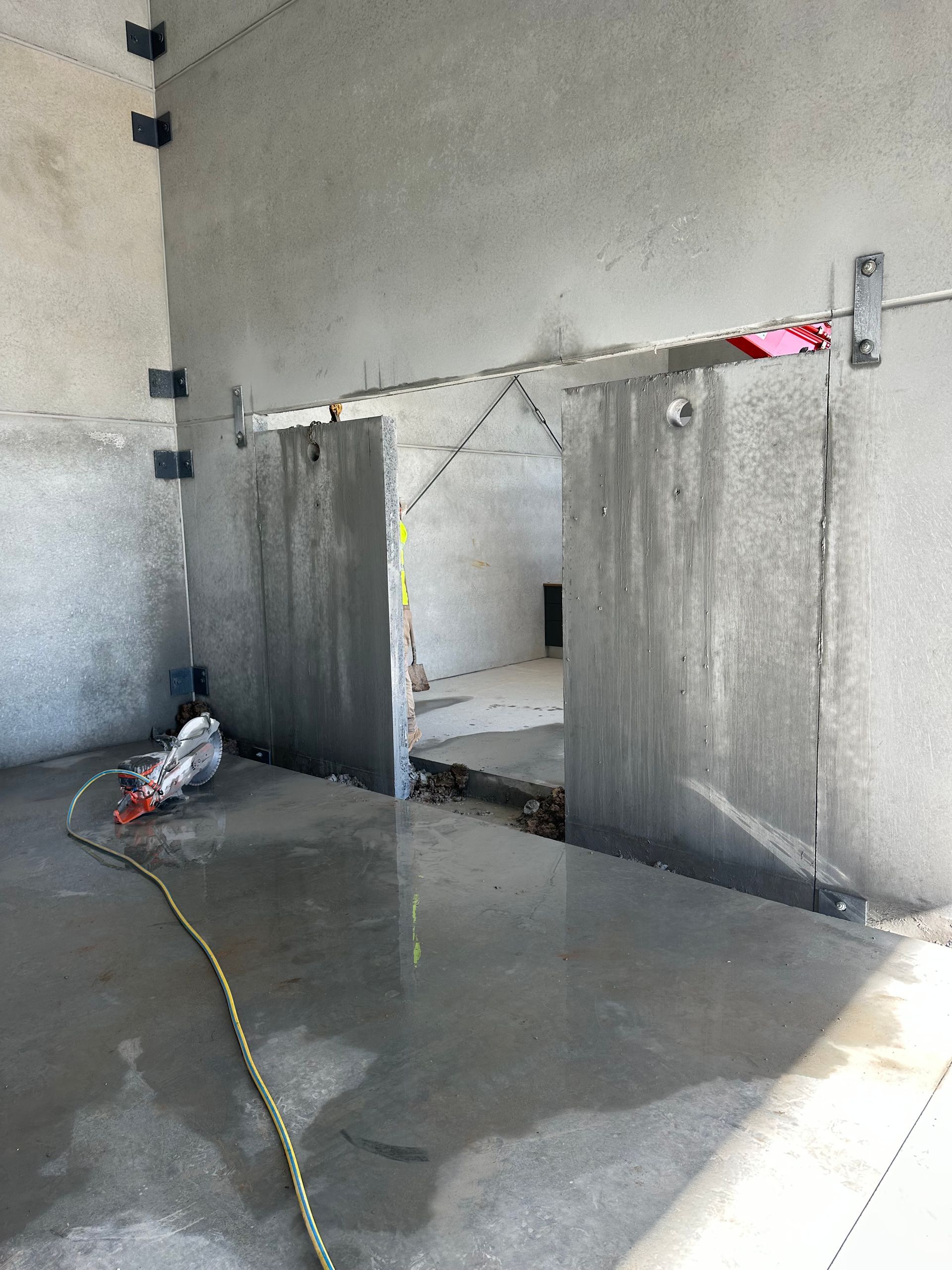 Interior of a Warehouse With Open Doors, an Excavator — Coastcut Concrete Cutting Pty Ltd in Corlette, NSW