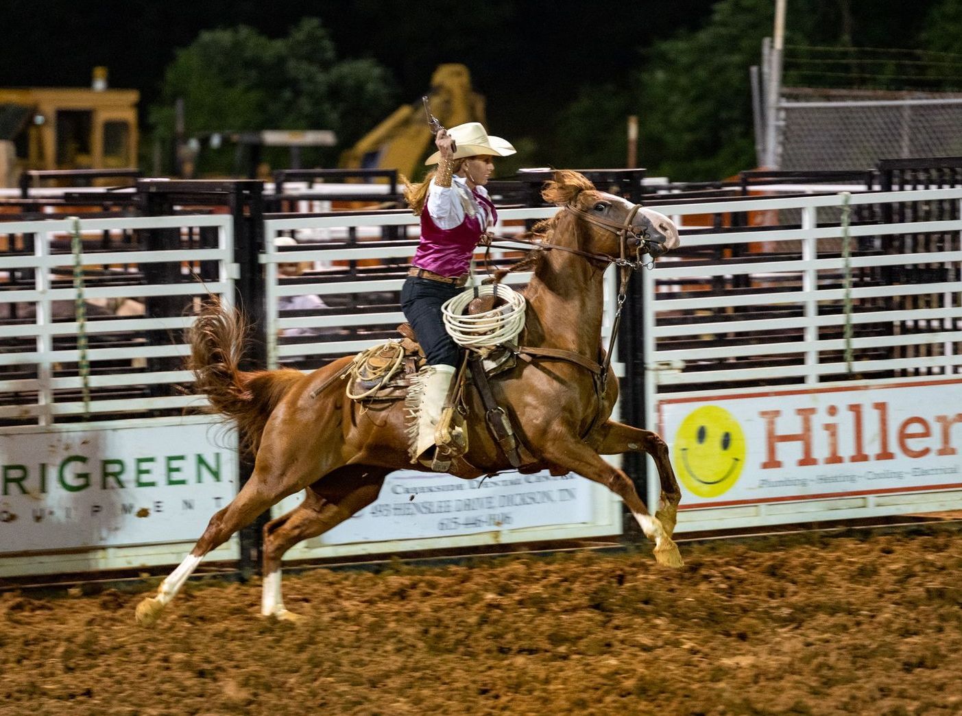 A woman is riding a horse in a rodeo arena