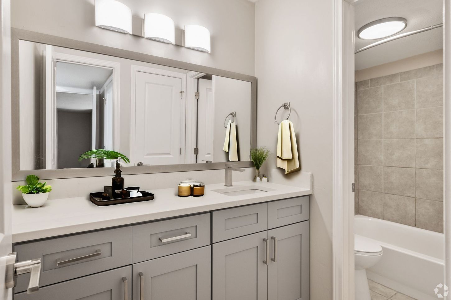 A bathroom with two sinks , two mirrors and a bathtub.