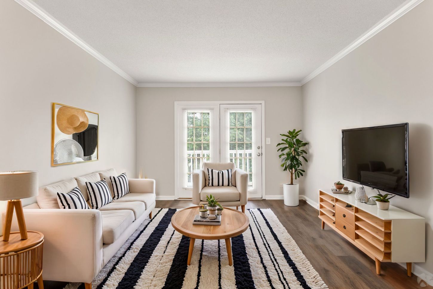 A living room with a couch , chair , coffee table and television.