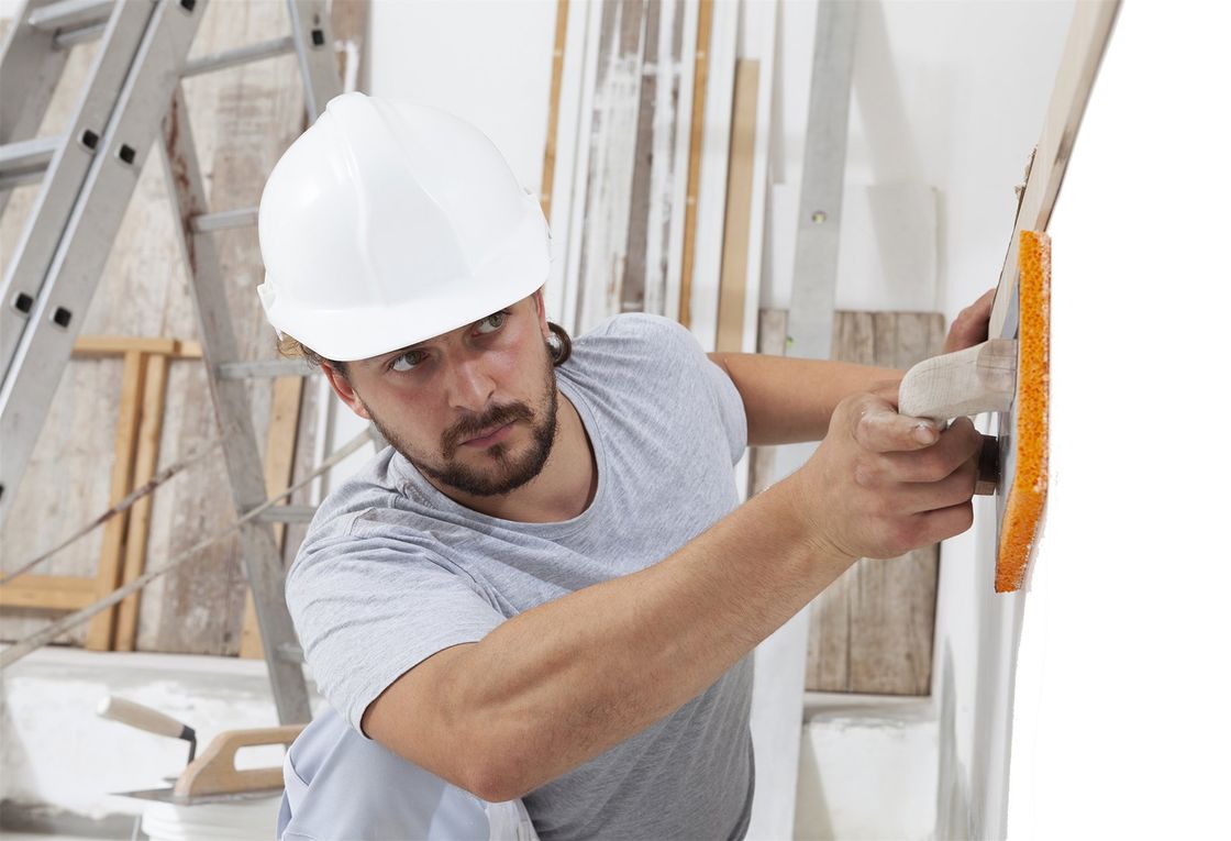 construction worker using sponge plastering trowel