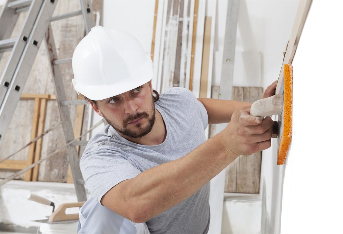 construction worker using sponge plastering trowel