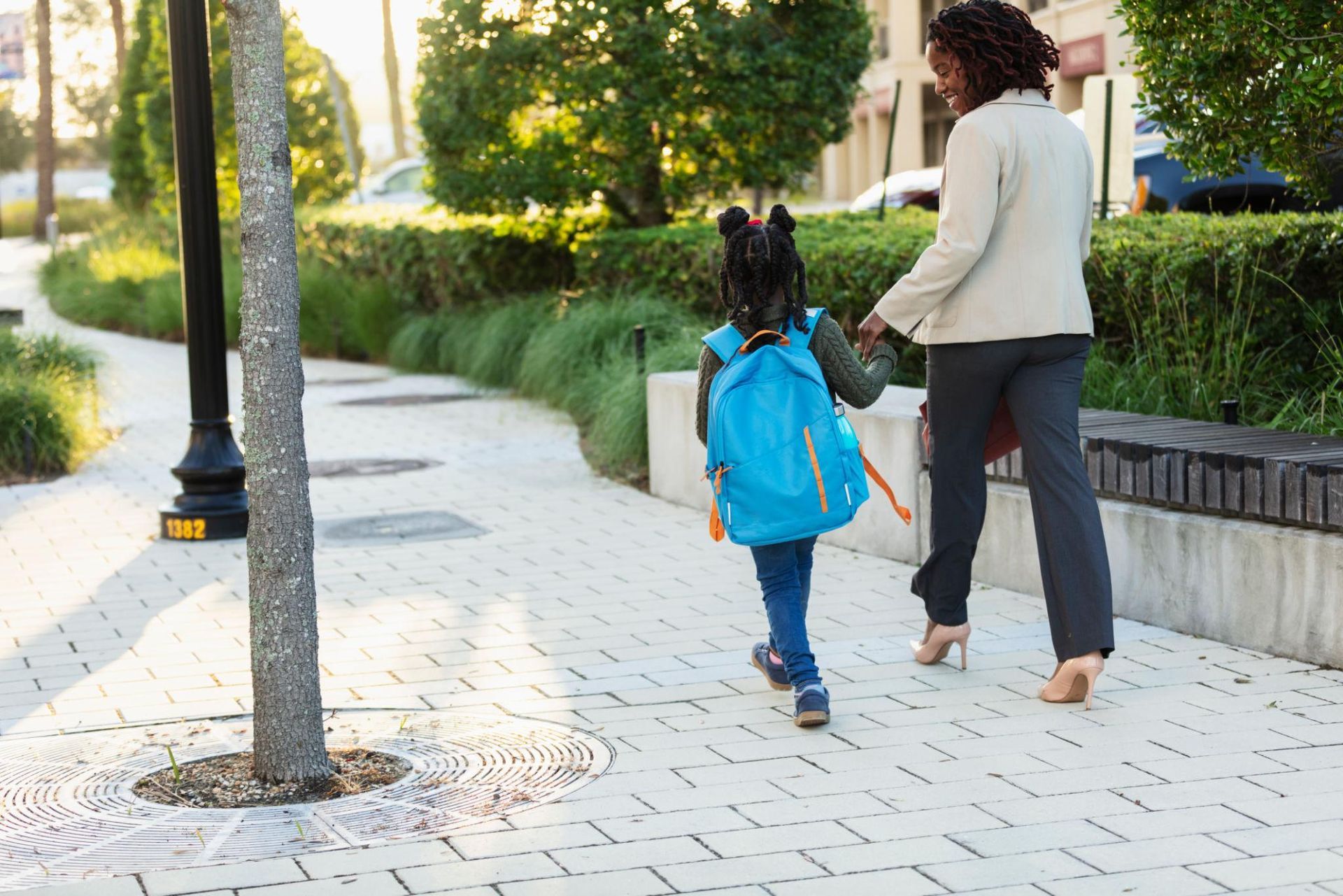 Mother walking child into school on the first day with confidence