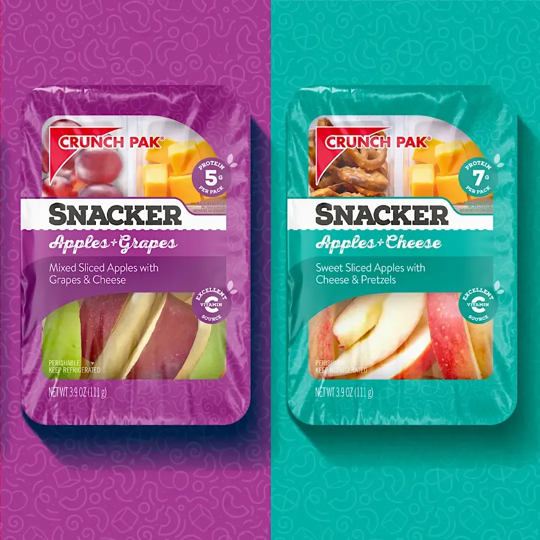 Two trays of Snacker apples and grapes on a purple and blue background.
