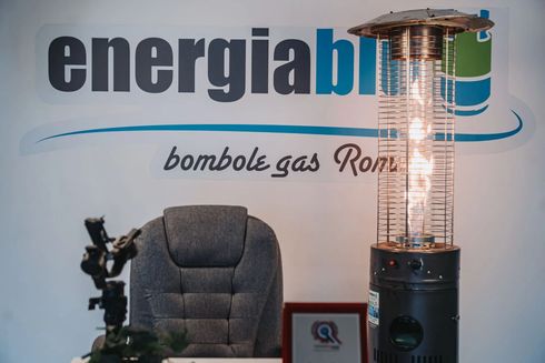 Atrio dell'ufficio con logo Energiabomb, sedia grigia e riscaldatore da esterno alto.