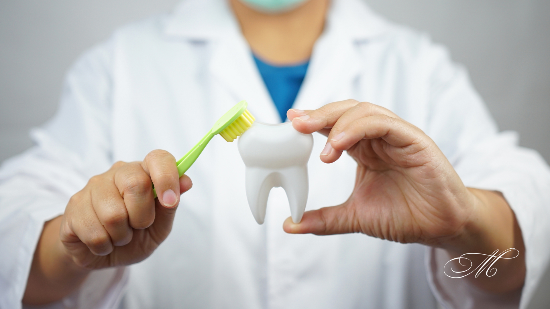 A dentist is holding a tooth and a toothbrush in his hands.