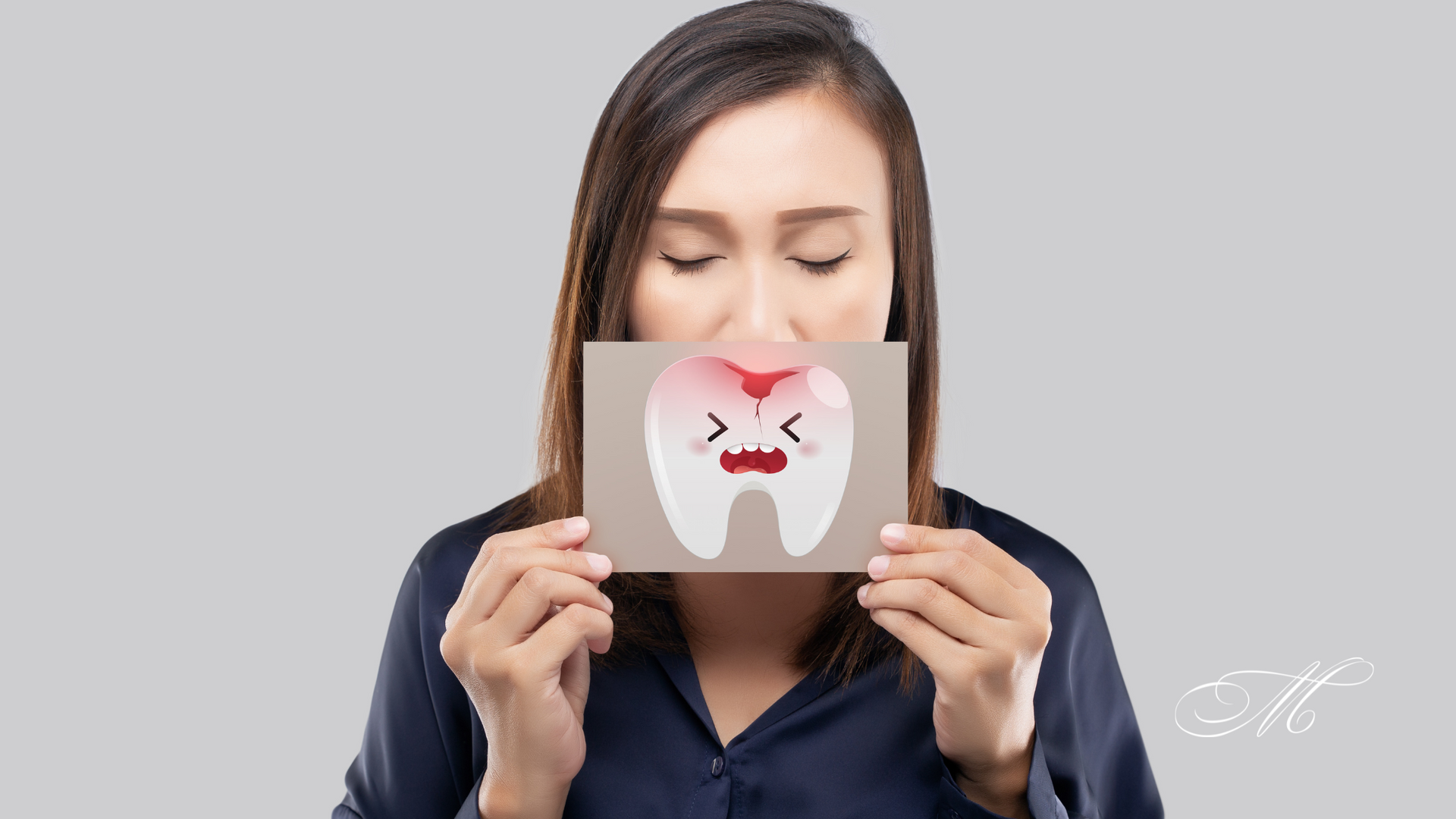 A woman is holding a card with a tooth on it in front of her face.