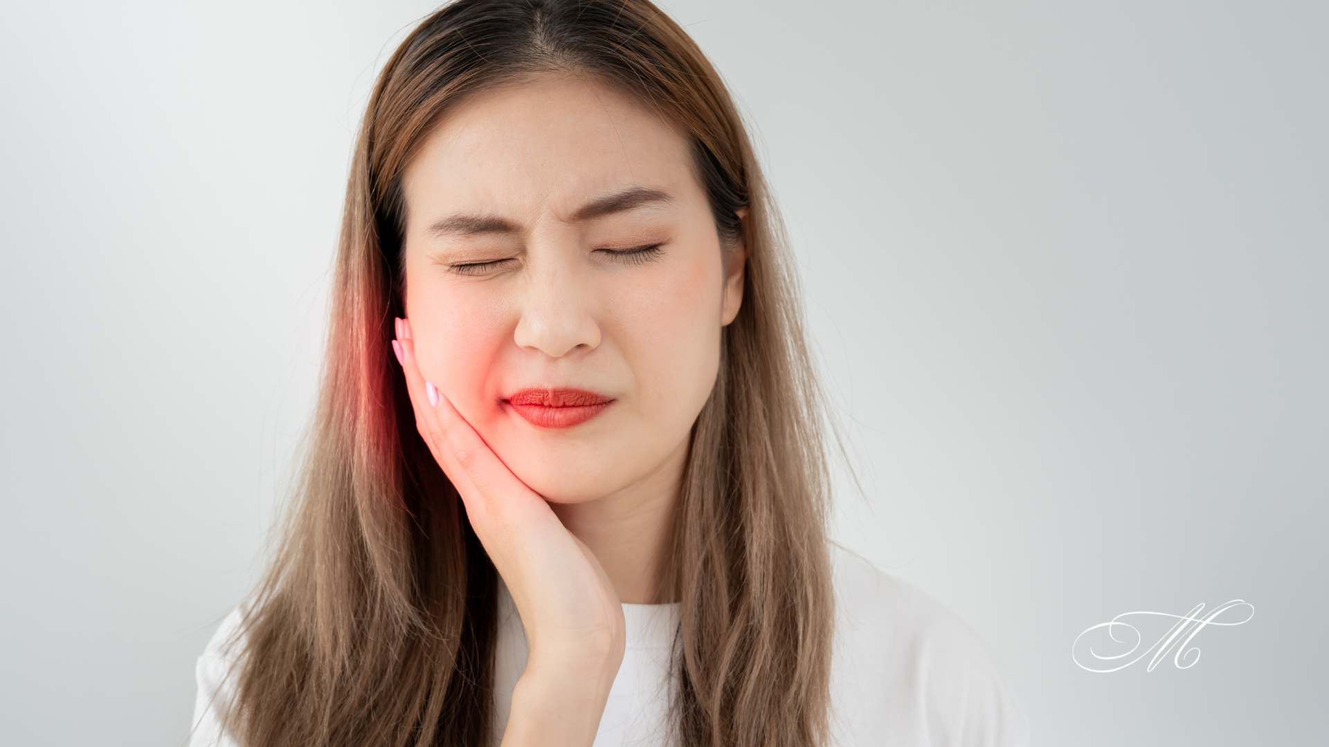 A woman is holding her face in pain because of a toothache.