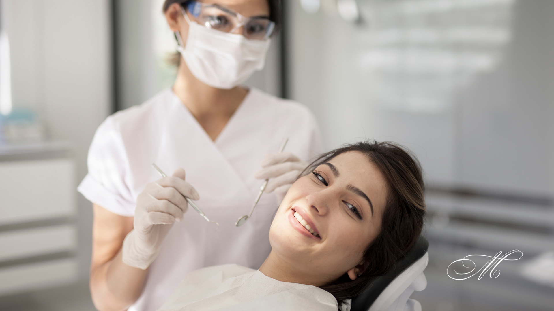 A woman is sitting in a dental chair while a dentist examines her teeth.