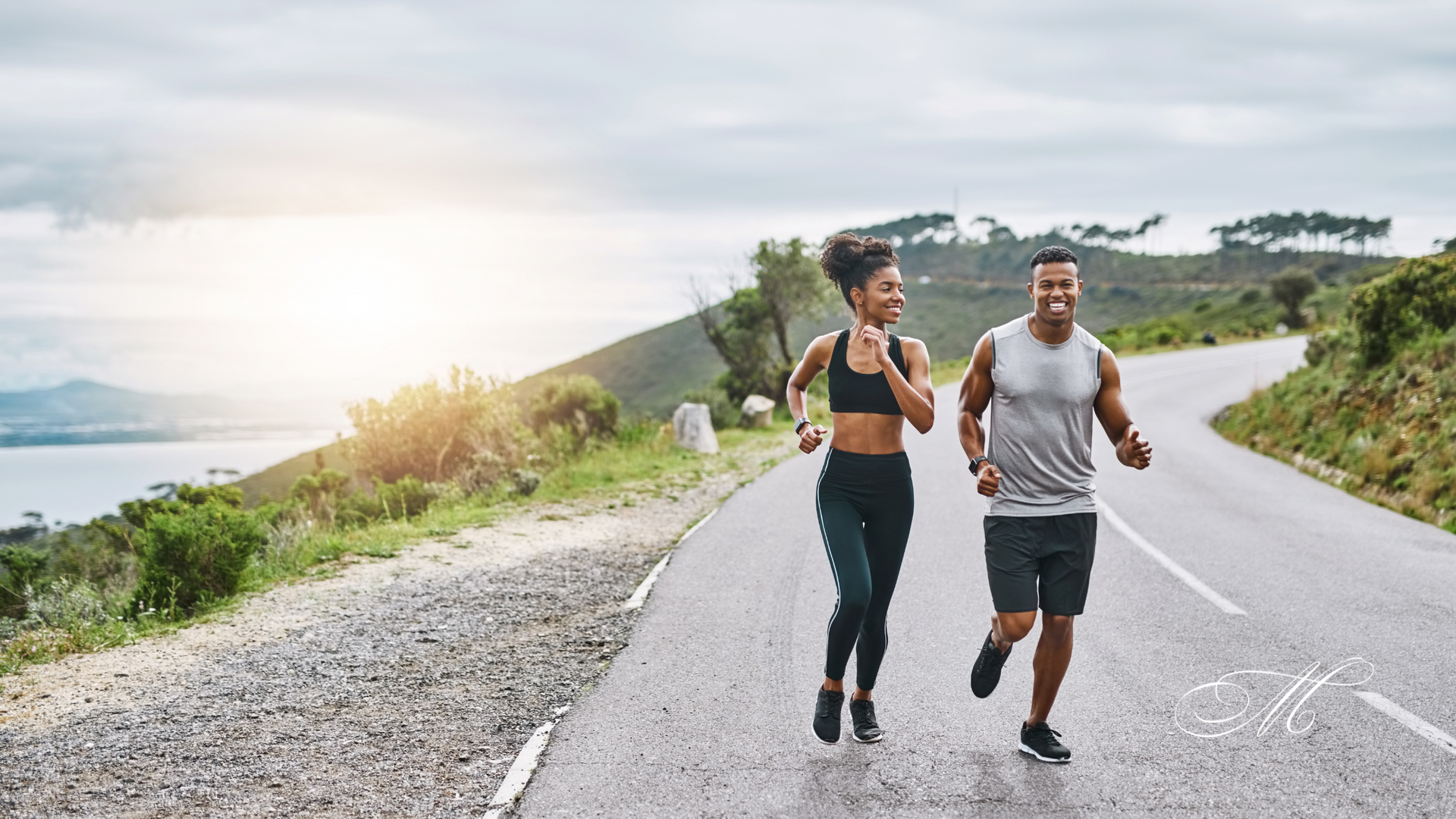 A man and a woman are running down a road.