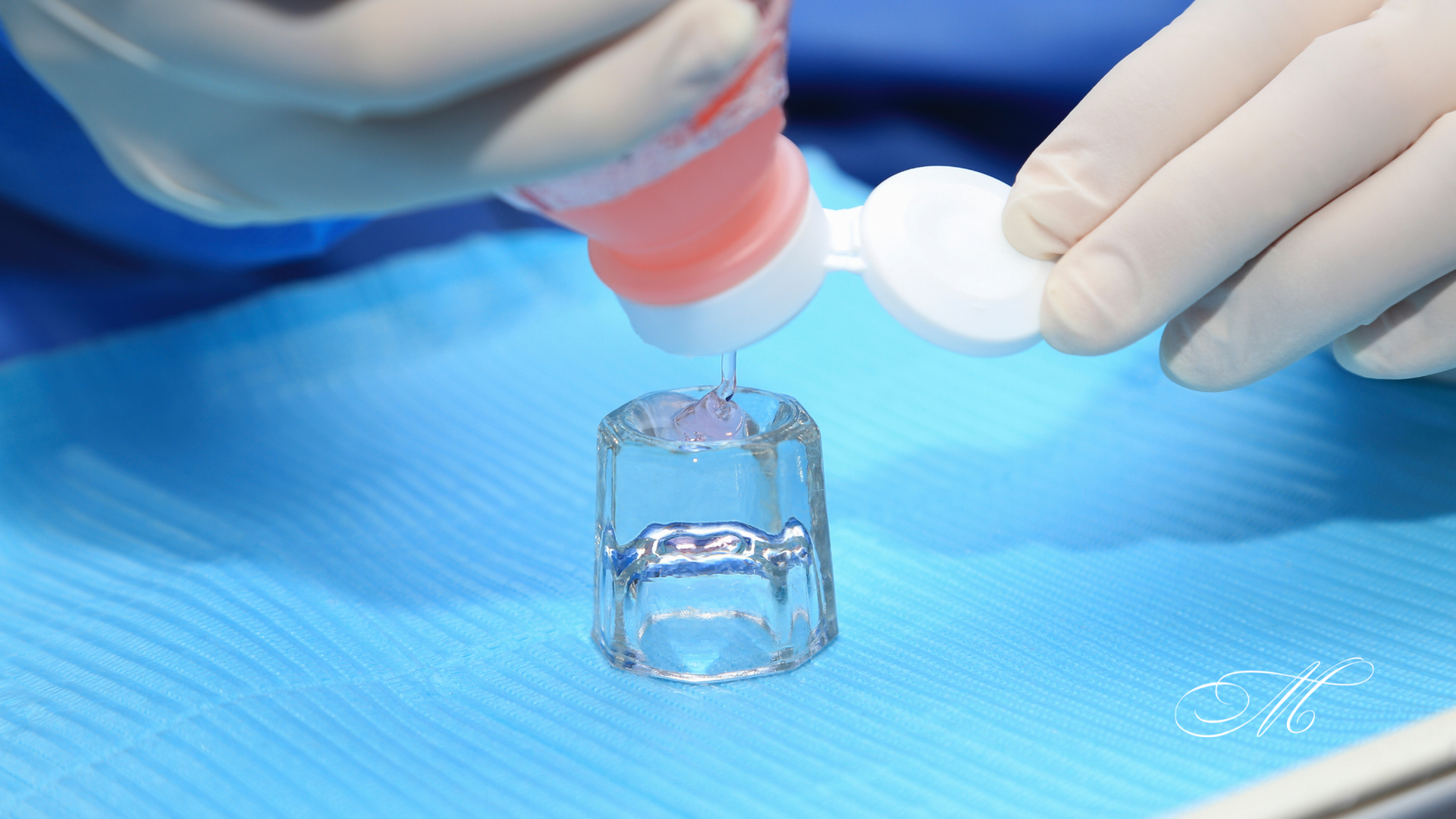 A person is pouring liquid into a glass on a table.