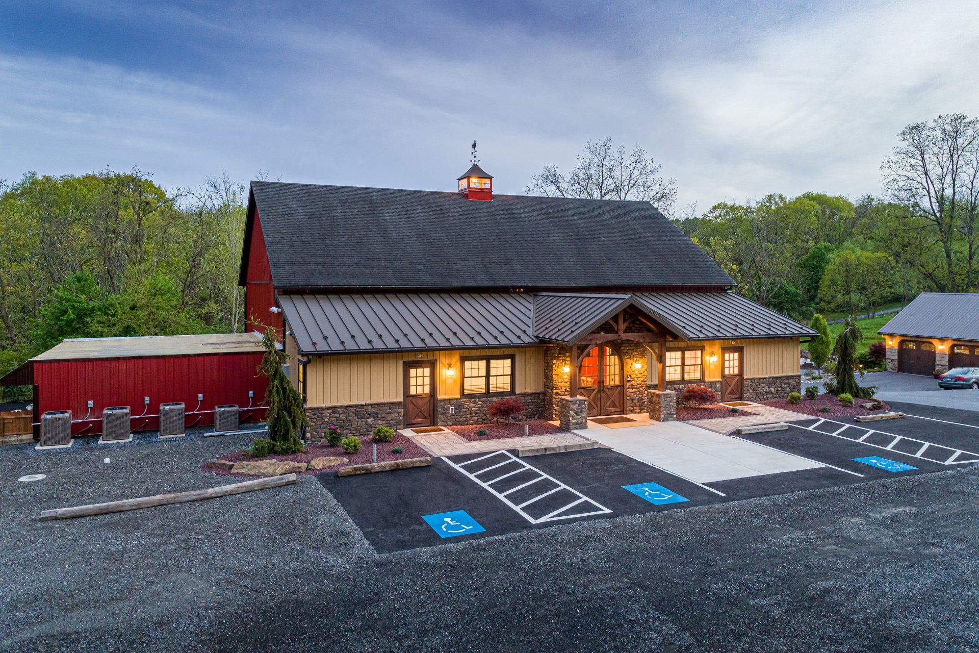 Red barn restaurant with tan siding, outdoor seating, and accessible parking.