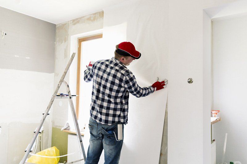 man hanging drywall