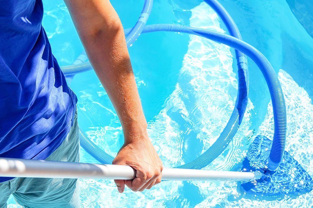 Technician maintaining a residential swimming pool with a vacuum hose in Baton Rouge,
Louisiana.