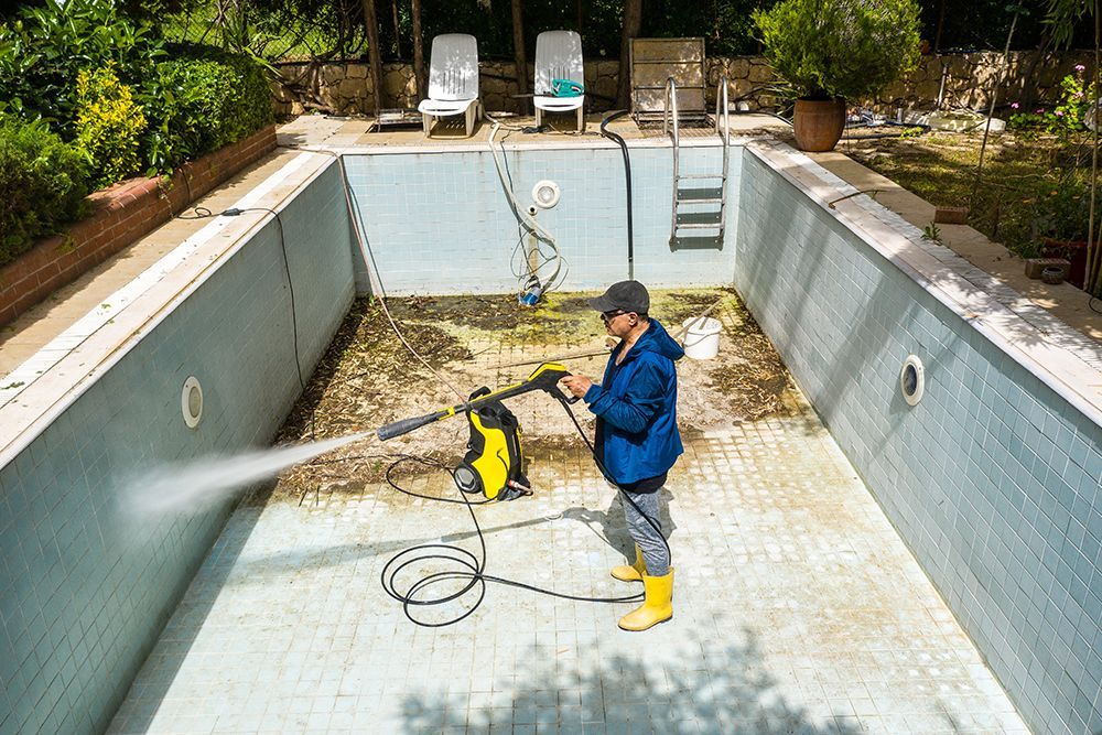 Empty swimming pool undergoing tile and surface pressure washing in Baton Rouge, Louisiana.