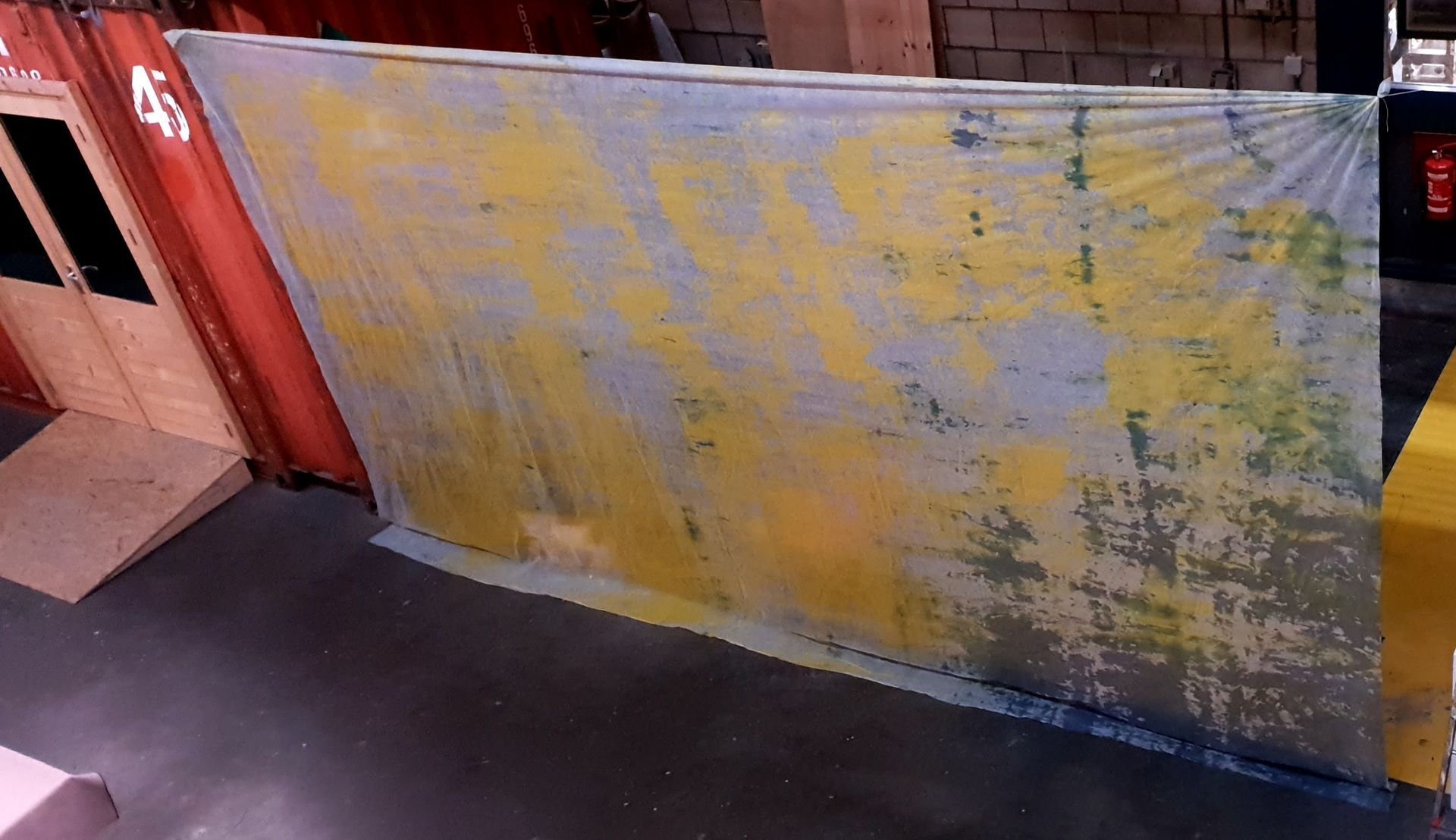 Een grote doorzichtige backdrop met gele verfvlekken 