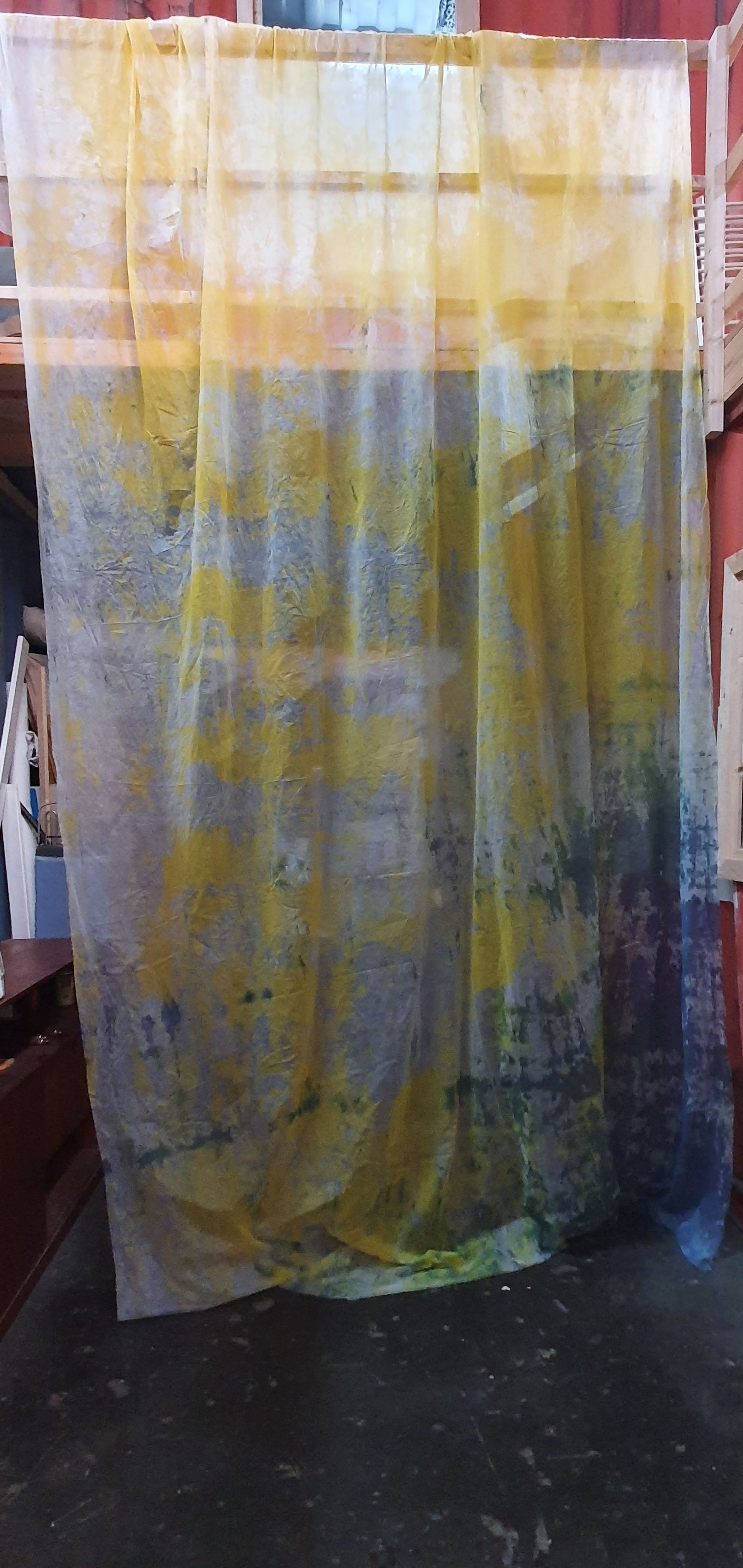 Abstract  geel op een doorschijnend gordijn met gele, blauwe en groene verfspetters, hangend. Doorzichtig.
