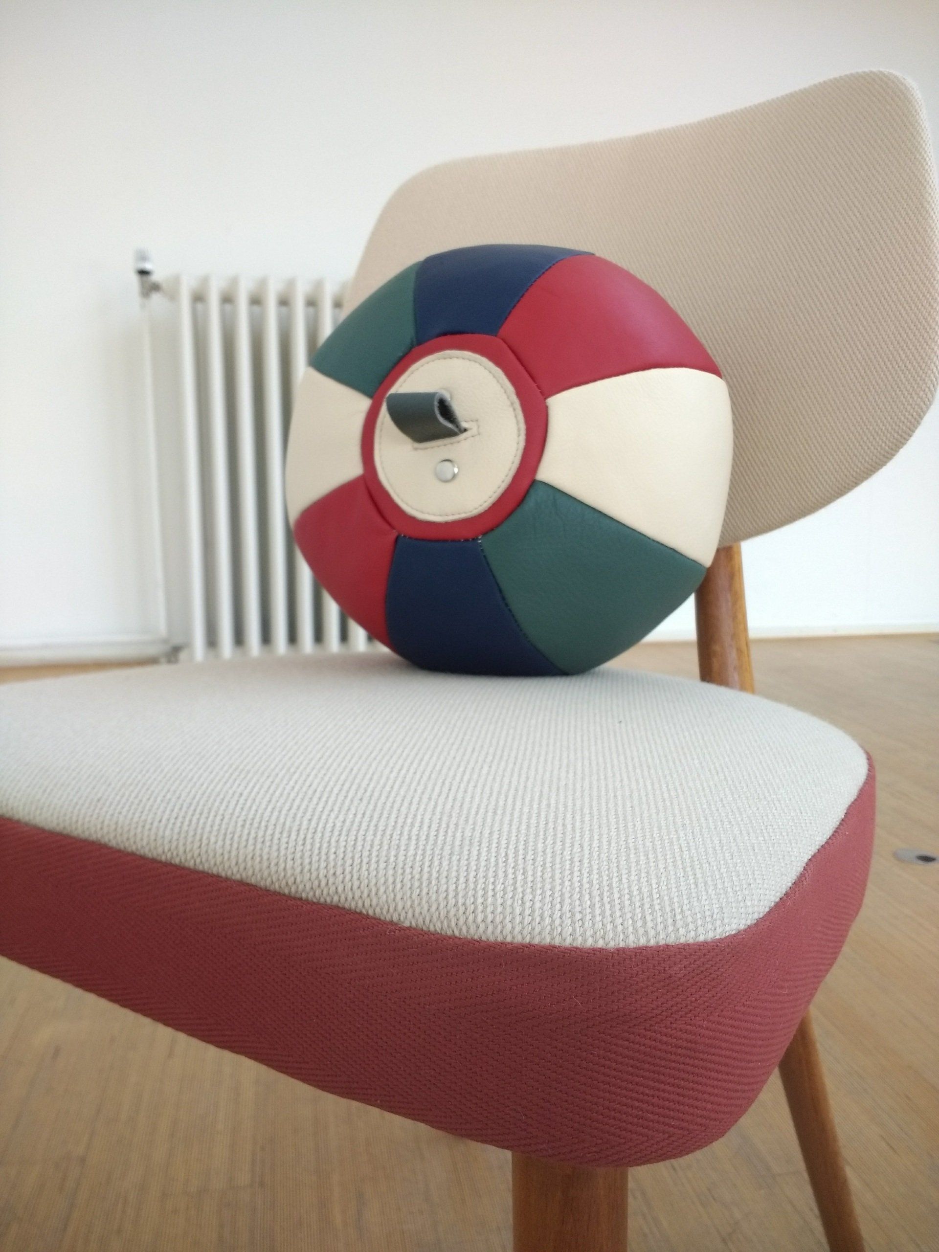 Veelkleurige bal op een stoel met rood en beige eco stof.
