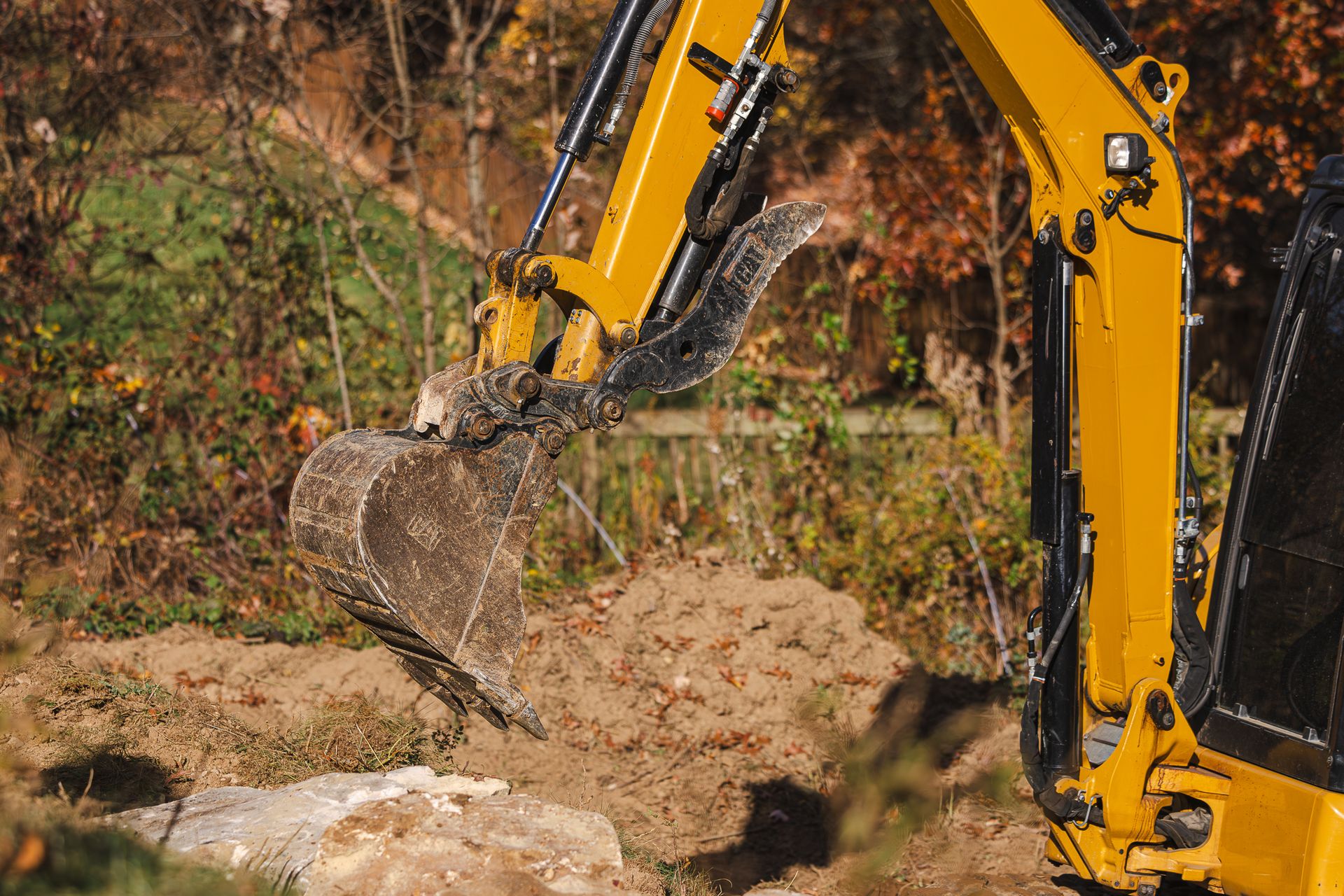 A yellow excavator is digging a hole in the ground.