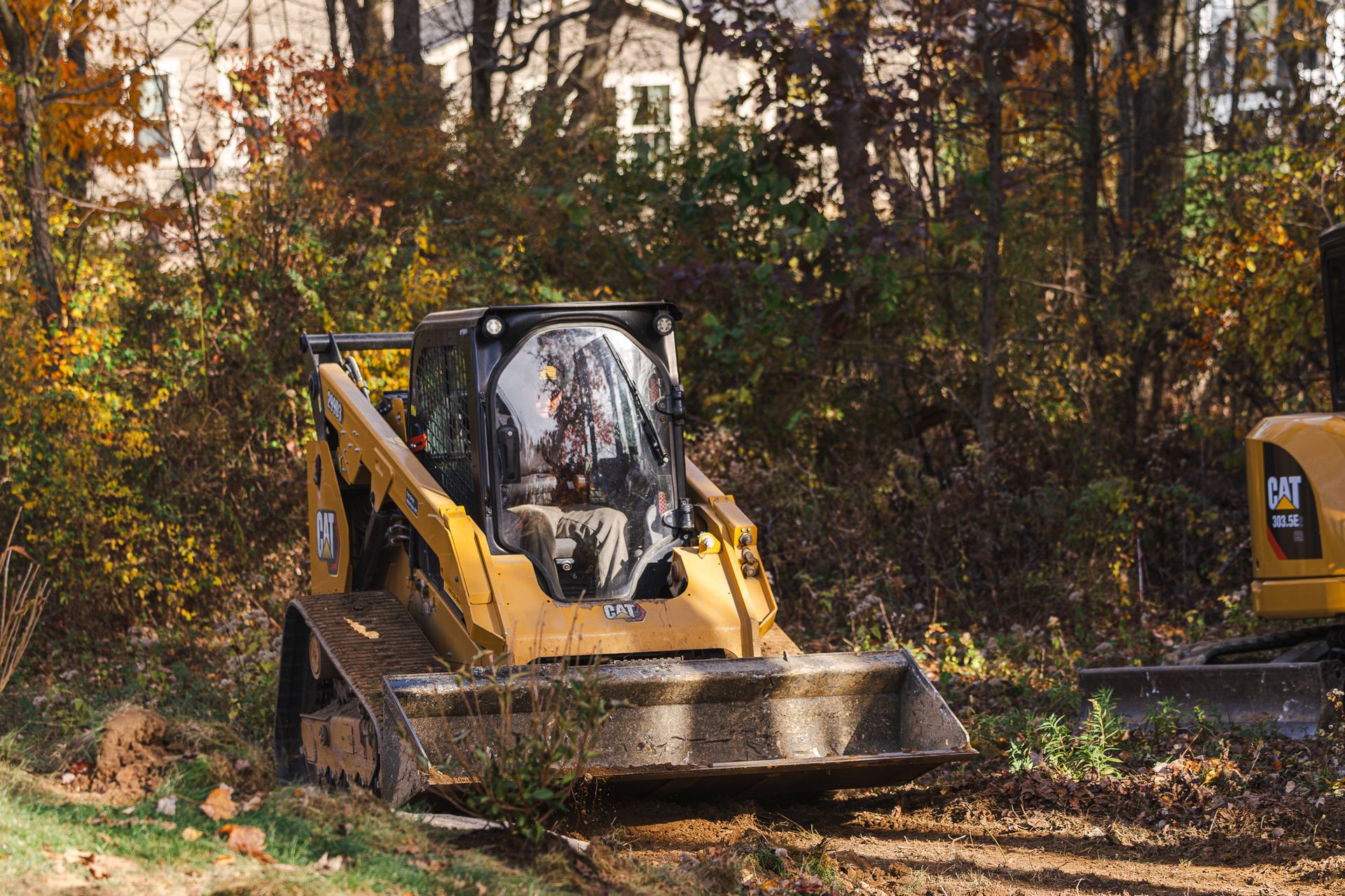 A cat bulldozer is driving down a dirt road