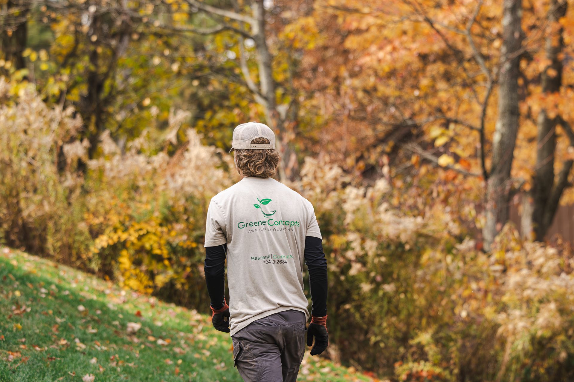 A man is walking down a path in the woods.