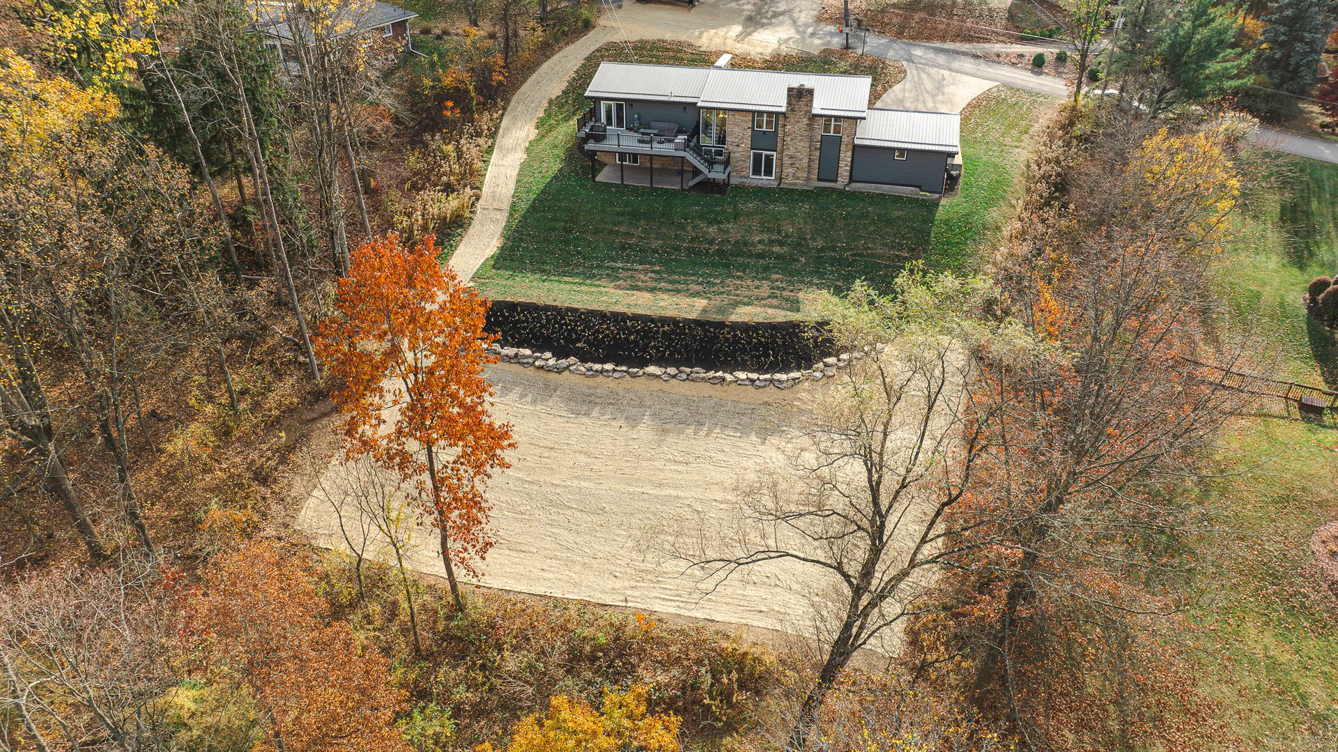 An aerial view of a house in the middle of a forest.