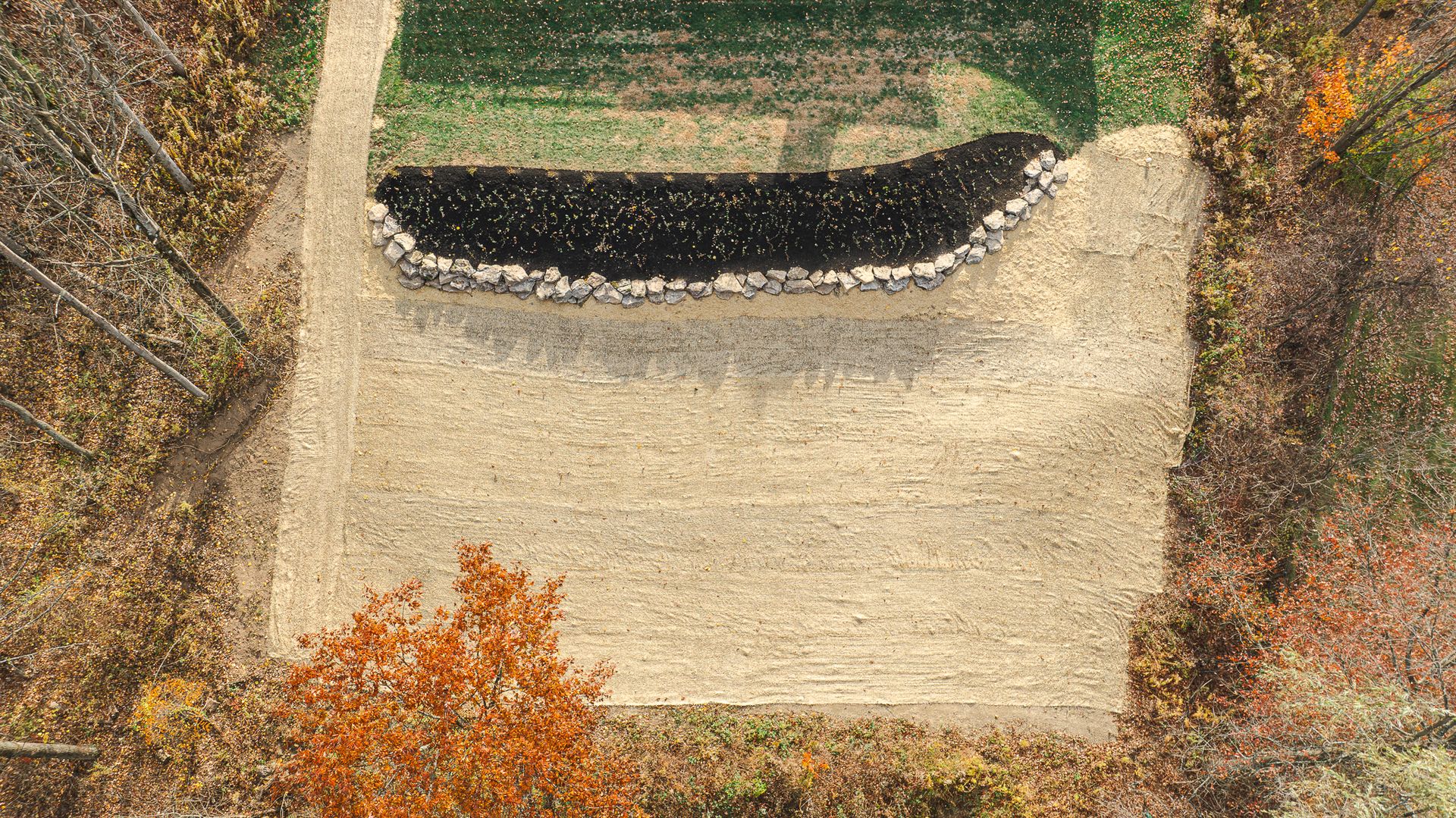 An aerial view of a golf course surrounded by trees.