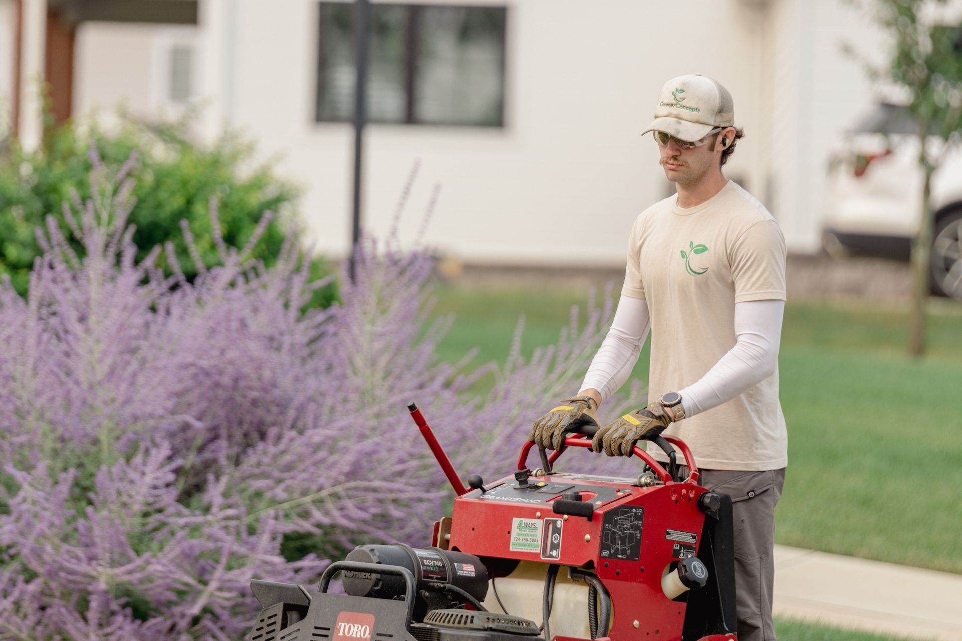 A man is standing next to a red lawn mower.