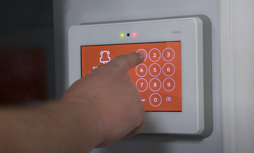 A person is pressing a button on a security system.