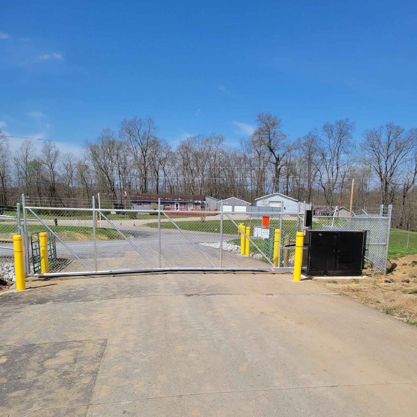 A sliding gate with yellow poles on the side of it