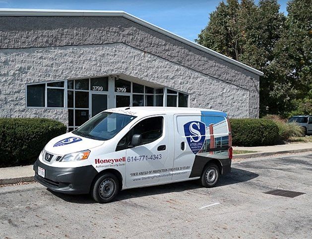 A white van is parked in front of a building.