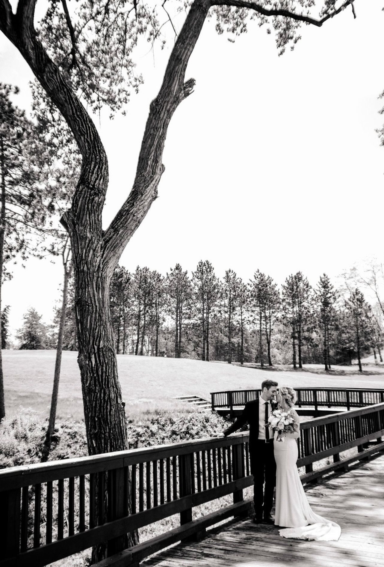 Image of wedding couple walking over the course bridge.