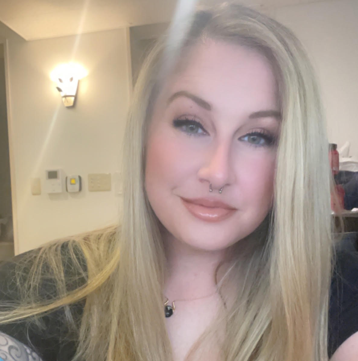 A woman with long blonde hair is smiling for the camera