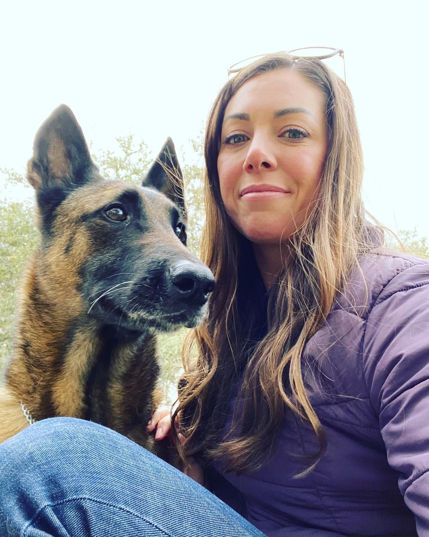 A woman is taking a selfie with her dog.