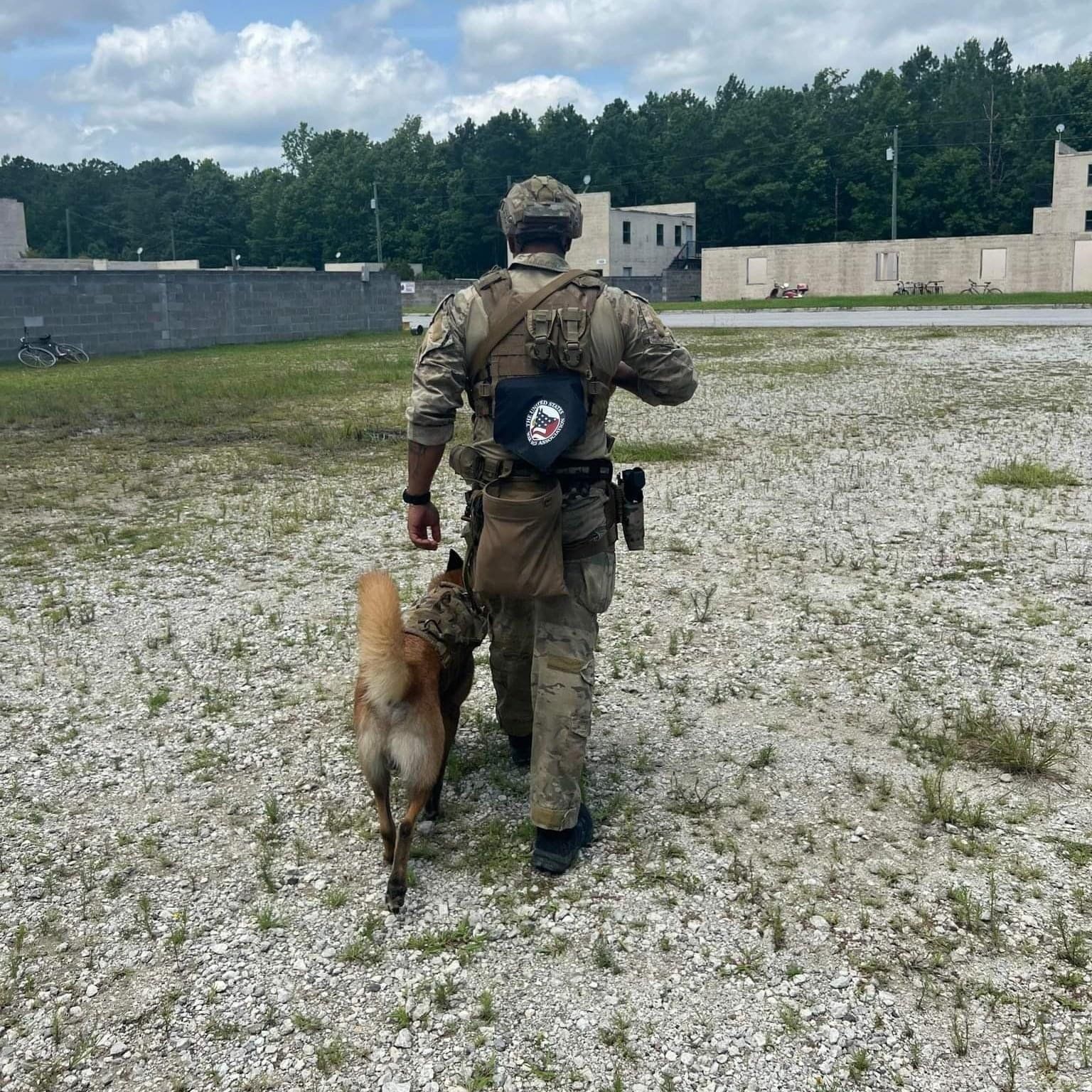 A man in a military uniform is walking a dog