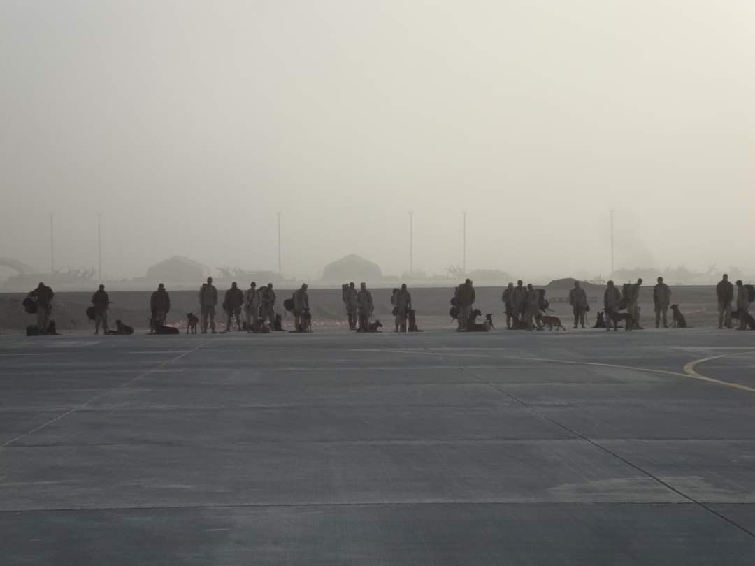 A group of people are standing in a line on a runway.