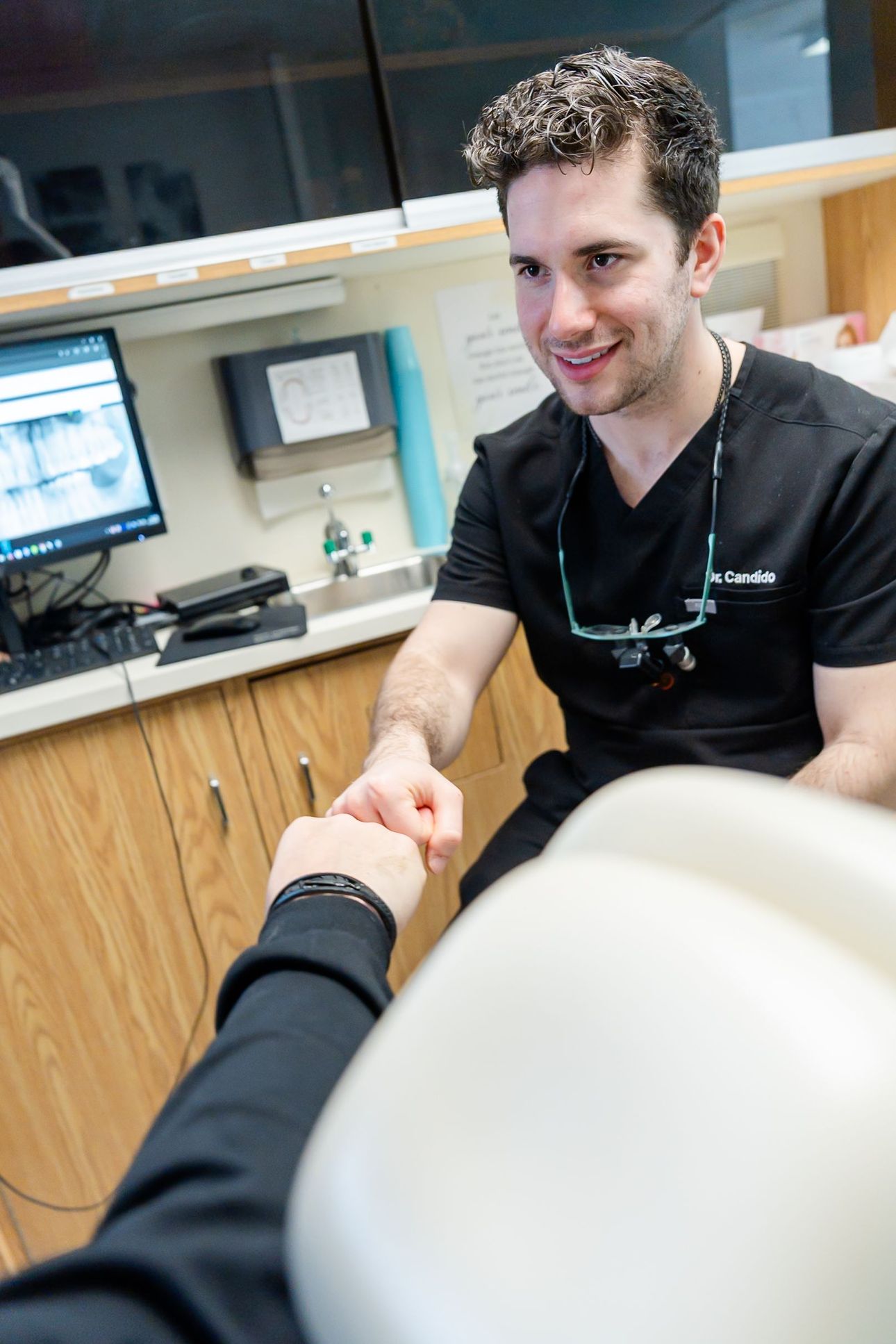 Dr. Candido shaking hands with a patient in the chair at Rome Dental