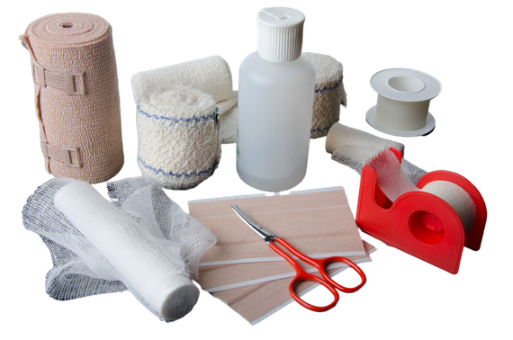 Vari tipi di bende mediche, garze, forbici, nastro adesivo e materiale di primo soccorso su sfondo bianco.