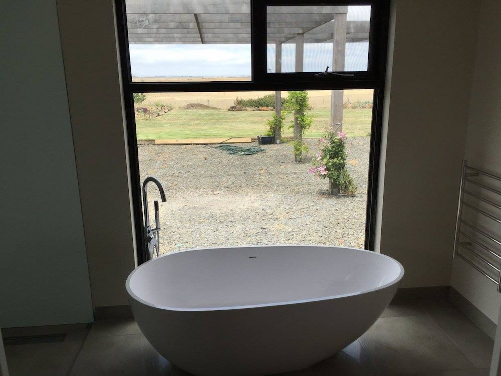 A Bathtub Is Sitting In Front Of A Window In A Bathroom — Justin Drew Plumbing in Grovedale, VIC