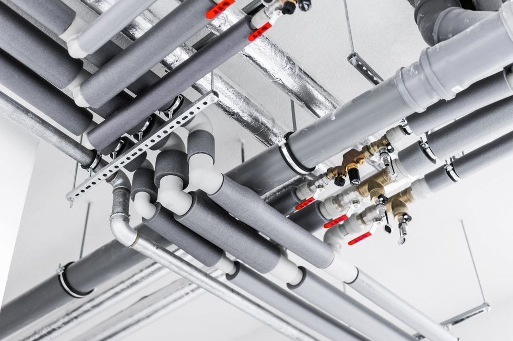 A Bunch Of Pipes Are Hanging From The Ceiling Of A Building — Justin Drew Plumbing in Torquay, VIC