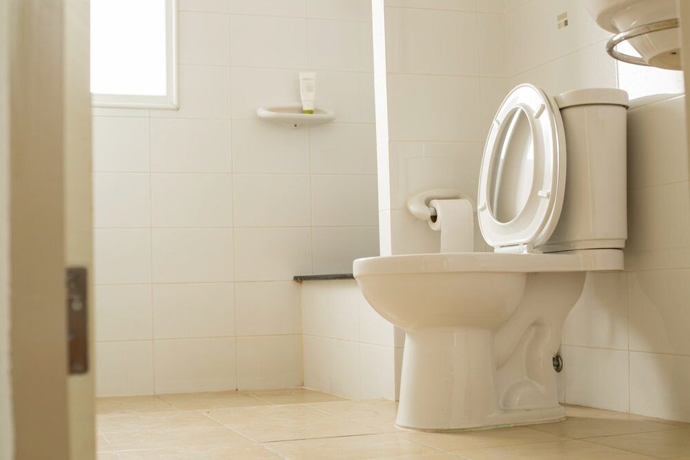 A White Toilet Is Sitting In A Bathroom Next To A Sink — Justin Drew Plumbing in Grovedale, VIC