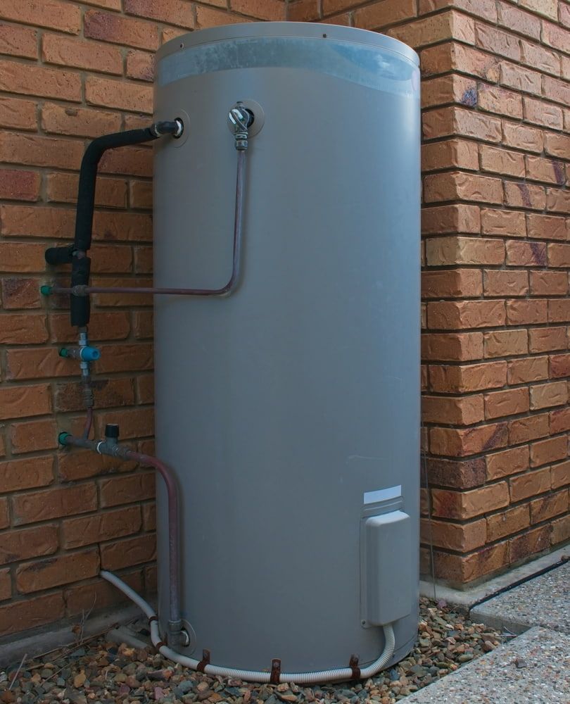 A Grey Water Heater Is Attached To A Brick Wall — Justin Drew Plumbing in Grovedale, VIC