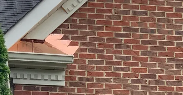 copper roof flashing on a brick wall